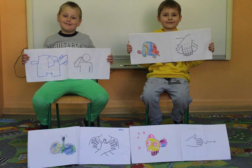 Dzieci prezentują słowniczek migowy.